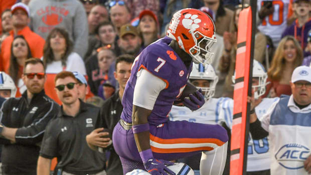 Clemson Tigers running back Phil Mafah leaps over The Citadel Bulldogs defensive back Cale Williams.