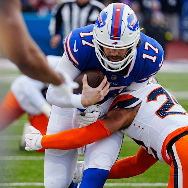 Buffalo Bills quarterback Josh Allen gets tackled by Denver Broncos safety Brandon Jones