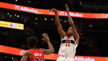 Oct 12, 2025; Washington, District of Columbia, USA; Washington Wizards guard Tre Johnson (12) shoots the ball over Toronto Raptors guard Ochai Agbaji (30) in the second half at Capital One Arena. Mandatory Credit: Geoff Burke-Imagn Images