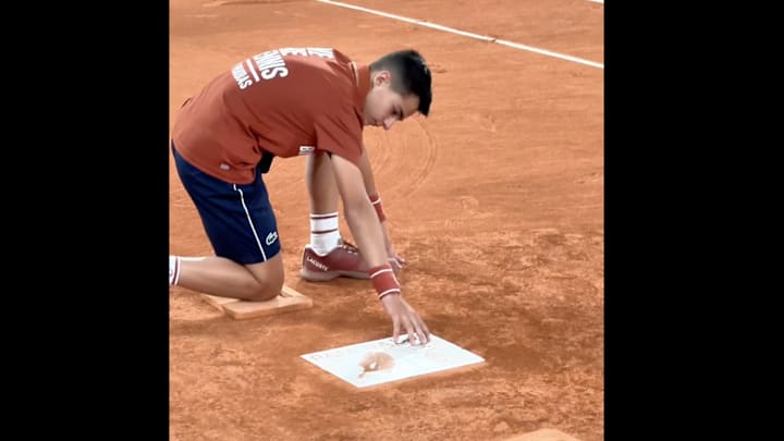 A ball boy touches the Rafael Nadal plaque at the French Open.