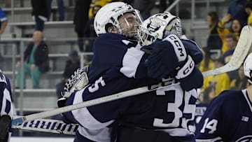 Penn State men's hockey defenseman Casey Aman celebrates with former Penn State goaltender Arsenii Sergeev
