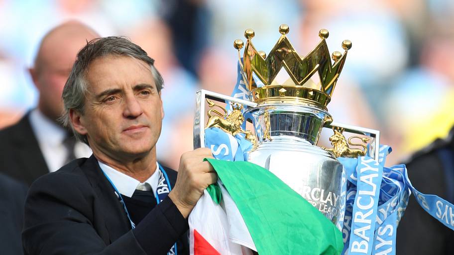 Roberto Mancini holding an Italy flag and the trophy.