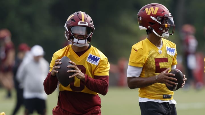 Jul 25, 2024; Ashburn, VA, USA; Washington Commanders quarterbacks Marcus Mariota (0) and Jayden Daniels (5) drop back to pass a ball during drills on day two of Commanders training camp at OrthoVirginia Training Center at Commanders Park. Mandatory Credit: Geoff Burke-USA TODAY Sports