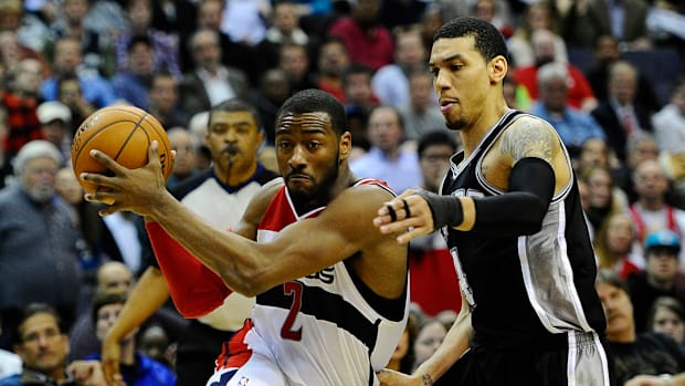 Washington Wizards point guard John Wall drives to the basket while San Antonio Spurs shooting guard Danny Green defends.