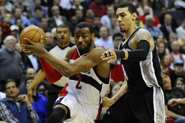 Washington Wizards point guard John Wall drives to the basket as San Antonio Spurs shooting guard Danny Green defends.