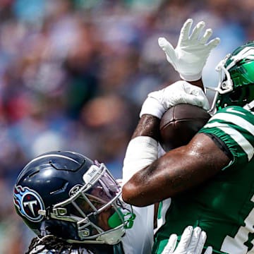 New York Jets wide receiver Mike Williams (18) receives a pass over Tennessee Titans cornerback Chidobe Awuzie (13) during the fourth quarter at Nissan Stadium in Nashville, Tenn., Sunday, Sept. 15, 2024.