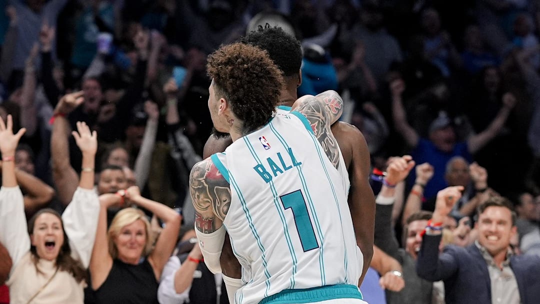 Nov 6, 2024; Charlotte, North Carolina, USA; Fans react as Charlotte Hornets guard LaMelo Ball (1) jumps on the back of forward Brandon Miller (24) after his final second put back wins the game against the Detroit Pistons during the second half at Spectrum Center. Mandatory Credit: Jim Dedmon-Imagn Images