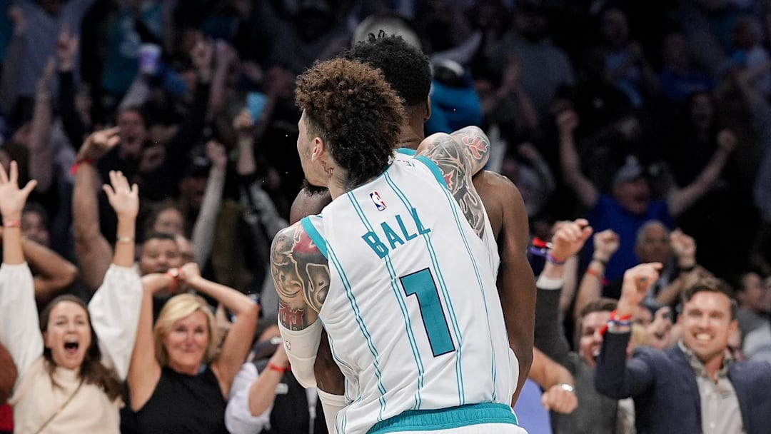 Nov 6, 2024; Charlotte, North Carolina, USA; Fans react as Charlotte Hornets guard LaMelo Ball (1) jumps on the back of forward Brandon Miller (24) after his final second put back wins the game against the Detroit Pistons during the second half at Spectrum Center. Mandatory Credit: Jim Dedmon-Imagn Images