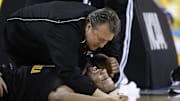 Apr 3, 2010; Indianapolis, IN, USA; West Virginia Mountaineers forward Da'Sean Butler (bottom) is looked after by head coach Bob Huggins after being injured during the second half of the semifinals of the Final Four of the 2010 NCAA mens basketball tournament against the Duke Blue Devils at Lucas Oil Stadium. Mandatory Credit: Bob Donnan-Imagn Images