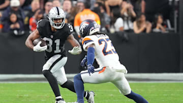 Dec 7, 2025; Paradise, Nevada, USA;  Las Vegas Raiders running back Raheem Mostert (31) carries the ball as Denver Broncos cornerback Jahdae Barron (23) defends during the second half at Allegiant Stadium. Mandatory Credit: Stephen R. Sylvanie-Imagn Images
