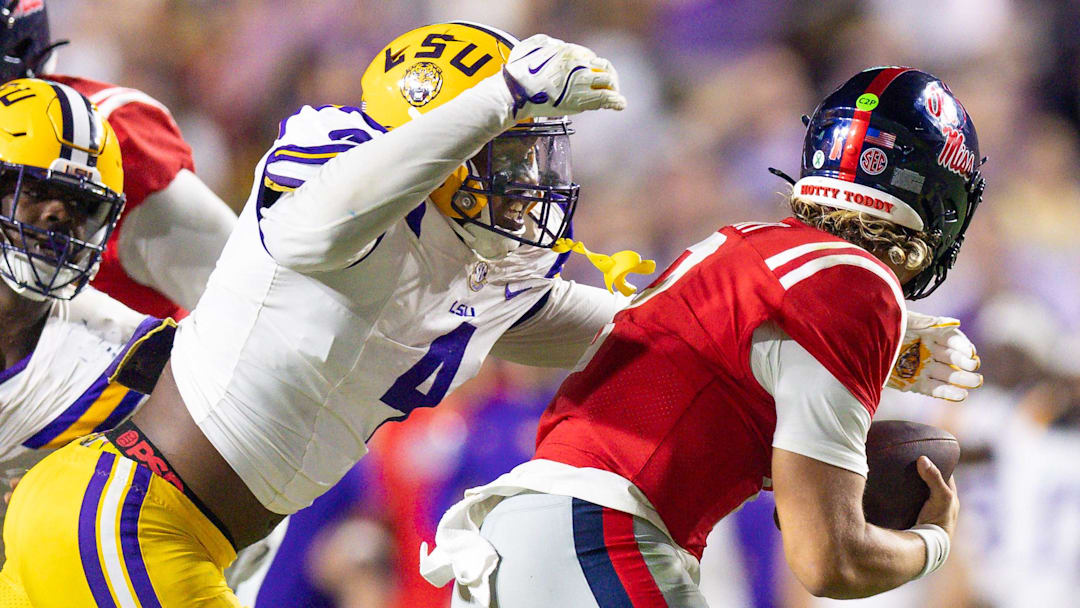 Oct 12, 2024; Baton Rouge, Louisiana, USA; LSU Tigers defensive end Bradyn Swinson (4) sacks Mississippi Rebels quarterback Jaxson Dart (2) during the second half at Tiger Stadium. Mandatory Credit: Stephen Lew-Imagn Images Oct 12, 2024; Baton Rouge, Louisiana, USA; LSU Tigers defensive end Bradyn Swinson (4) sacks Mississippi Rebels quarterback Jaxson Dart (2) during the second half at Tiger Stadium. Mandatory Credit: Stephen Lew-Imagn Images