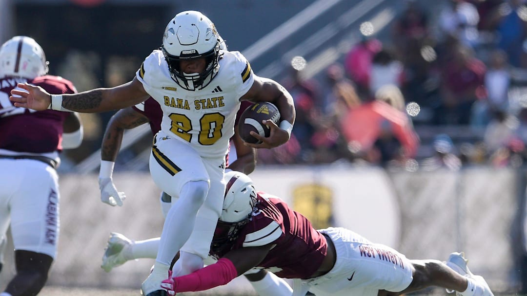 Alabama State running back Jamarie Hostzclaw (20) tries to elude Alabama A&M defensive back Marvin Smith (12) in the Magic City Classic at Legion Field in Birmingham, Ala., on Saturday, October 26, 2024.