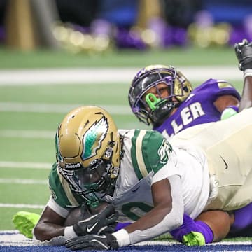 DeSoto's Myson Cook Johnson is tripped up by Miller's Delson Cavaness during Friday's game at the Alamodome on Sept. 13, 2024, in San Antonio, Texas.