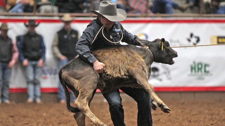 Ty Harris, right, competes in the tie down roping event.