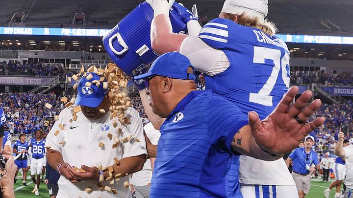 Dec 27, 2025; Orlando, FL, USA; BYU Cougars offensive lineman Kaden Chidester (79) dumps Pop-Tarts on head coach Kalani Sitake after beating Georgia Tech Yellow Jackets in the Pop-Tarts Bowl at Camping World Stadium. Mandatory Credit: Nathan Ray Seebeck-Imagn Images