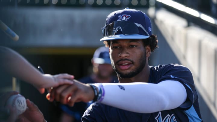 Hooks' Brice Matthews signs baseballs for fans before the game against the Amarillo Sod Poodles at Whataburger Field on Thursday, August 1, 2024, in Corpus Christi, Texas.