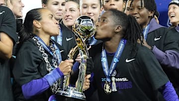 Nov 23, 2024; Kansas City, Missouri, USA;  Orlando Pride forward Marta (10) and Orlando Pride forward Barbra Banda (22) kiss the championship trophy after defeating the Washington Spirit in the 2024 NWSL Championship match at CPKC Stadium. Mandatory Credit: Jay Biggerstaff-Imagn Images