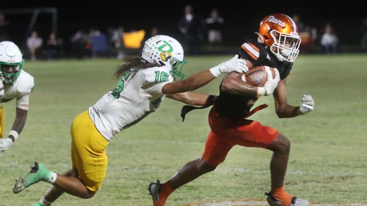 University High's Jermane Hayes #3 slips out of the reach of DeLand High's Michael Hamilton #16, Friday October 20, 2023.