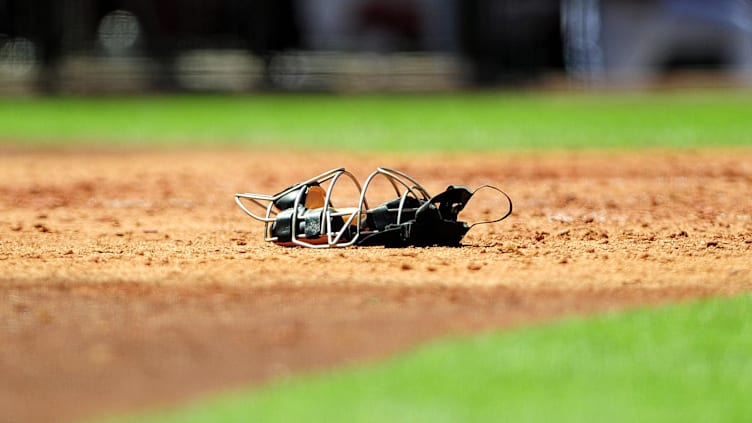 Detail view of a catchers mask as it lays on the field.