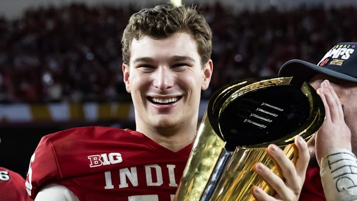 Jan 19, 2026; Miami Gardens, FL, USA; Indiana Hoosiers quarterback Fernando Mendoza (16) celebrates with the trophy after defeating the Miami Hurricanes in the College Football Playoff National Championship game at Hard Rock Stadium. Mandatory Credit: Mark J. Rebilas-Imagn Images