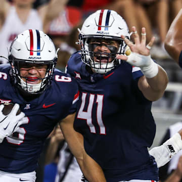 Aug 30, 2025; Tucson, Arizona, USA; Arizona Wildcats defensive lineman Mays Pese (99), linebacker Taye Brown (6), and defensive lineman Julian Saviinaea (41) all celebrate after they intercept the ball from the Hawaii Rainbow Warriors during the third quarter of the game at Arizona Stadium. Mandatory Credit: Aryanna Frank-Imagn Images