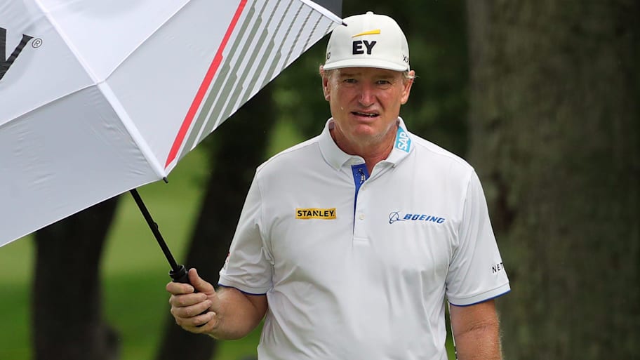 Ernie Els tries to stay dry in a light rain during the first round of the 2025 Kaulig Companies Championship.