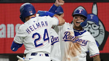 July 21, 2025; Arlington, Texas, USA; Texas Rangers outfielder Micheal Helman (24) elbow bumps Texas Rangers designated hitter Cody Freeman (39) after hitting a three-run home run at Globe Life Field. Helman collected his first MLB home run and Freeman his first MLB hit both in the fifth inning against the Athletics. 