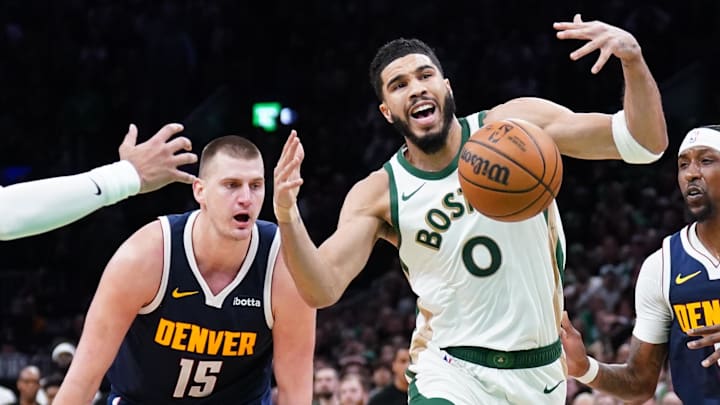 Jan 19, 2024; Boston, Massachusetts, USA; Boston Celtics forward Jayson Tatum (0) works for the ball against Denver Nuggets center Nikola Jokic (15), guard Jamal Murray (27) and guard Kentavious Caldwell-Pope (5) in the last seconds of the game at TD Garden. 