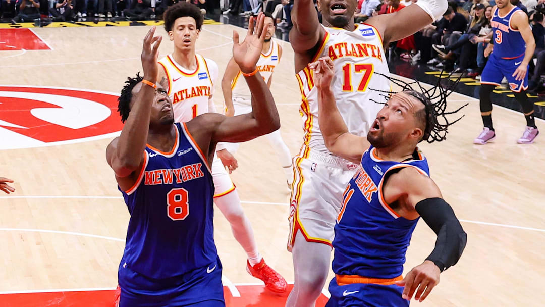 Atlanta Hawks forward Onyeka Okongwu (17) and New York Knicks forward Og Anunoby (8) and guard Jalen Brunson (11) reach for a rebound in the first half during game six of the first round of the 2026 NBA Playoffs at State Farm Arena. 