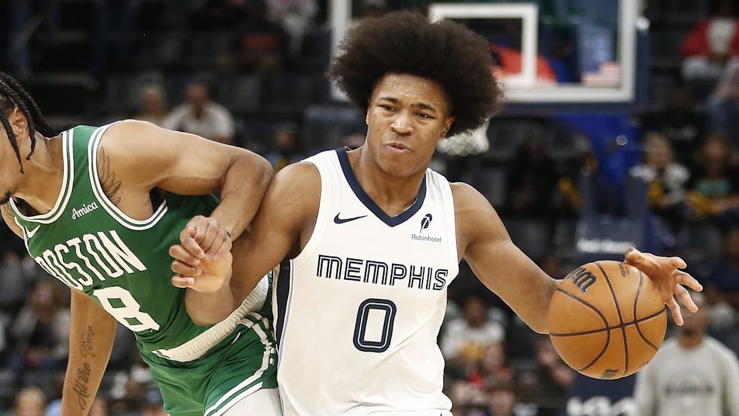 Oct 8, 2025; Memphis, Tennessee, USA; Memphis Grizzlies forward Jaylen Wells (0) dribbles as Boston Celtics forward Josh Minott (8) defends during the third quarter at FedExForum. Mandatory Credit: Petre Thomas-Imagn Images
