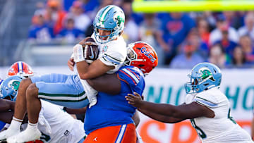 Desmond Watson tackles Tulane Green Wave quarterback Ty Thompson.