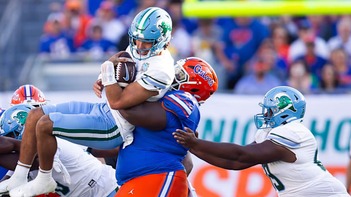 Desmond Watson tackles Tulane Green Wave quarterback Ty Thompson. Desmond Watson tackles Tulane Green Wave quarterback Ty Thompson.