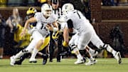 Oct 7, 2017; Ann Arbor, MI, USA; Michigan State Spartans quarterback Brian Lewerke (14) scrambles out of the pocket against the Michigan Wolverines during the second half of a game at Michigan Stadium. Mandatory Credit: Mike Carter-Imagn Images