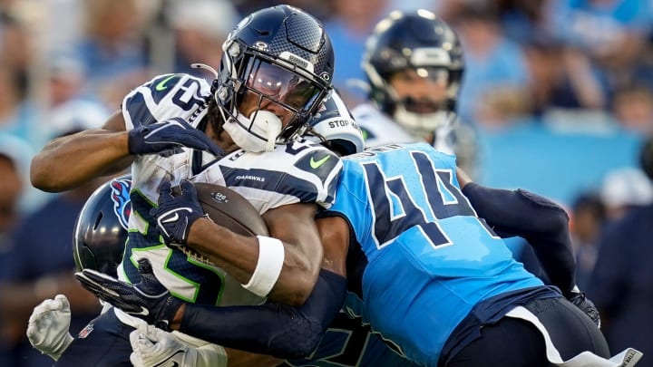 Seattle Seahawks running back Kenny McIntosh (25) is tackled byTennessee Titans safety Mike Brown (44) during the first quarter at Nissan Stadium in Nashville, Tenn., Saturday, Aug. 17, 2024.