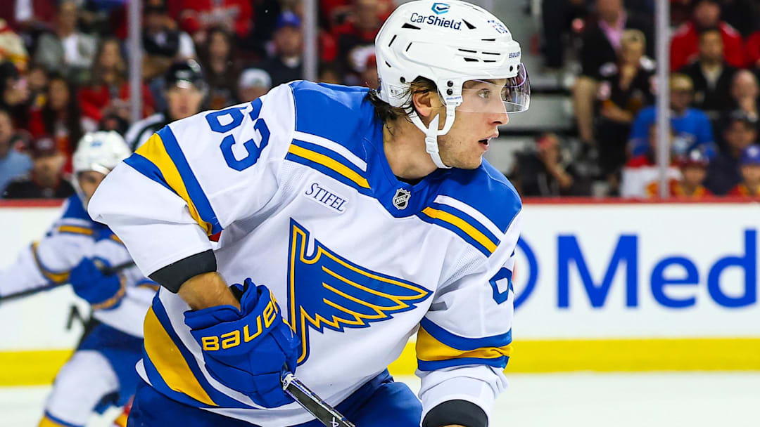 Oct 11, 2025; Calgary, Alberta, CAN; St. Louis Blues left wing Jake Neighbours (63) controls the puck against the Calgary Flames during the third period at Scotiabank Saddledome. Mandatory Credit: Sergei Belski-Imagn Images