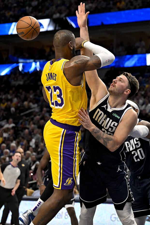 Los Angeles Lakers forward LeBron James passes the ball over Dallas Mavericks guard Luka Doncic