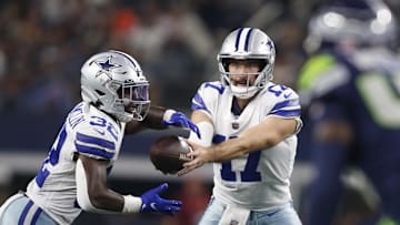 Aug 26, 2022; Arlington, Texas, USA; Dallas Cowboys quarterback Ben DiNucci (17) hands off to running back Aaron Shampklin (32) in the fourth quarter against the Seattle Seahawks at AT&T Stadium. Mandatory Credit: Tim Heitman-Imagn Images