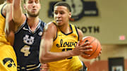 Dec 18, 2021; Sioux Falls, South Dakota, USA;  Iowa Hawkeyes forward Keegan Murray (15) drives on Utah State Aggies forward Brandon Horvath (4) in the second half at Sanford Pentagon. Mandatory Credit: Steven Branscombe-Imagn Images