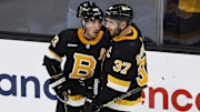 Boston Bruins center Patrice Bergeron congratulates left wing Brad Marchand after he scored against the Detroit Red Wings.