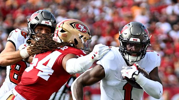 Tampa Bay Buccaneers running back Rachaad White (1) runs for a gain past San Francisco 49ers middle linebacker Fred Warner