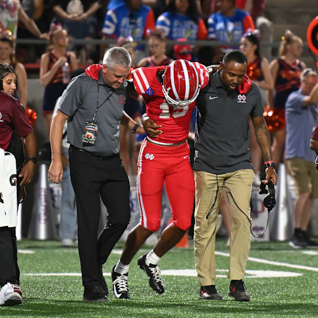 Mater Dei junior Chris Henry Jr. is helped off the field against Bishop Gorman after suffering from a leg injury on Friday, S