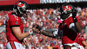 Nov 30, 2025; Tampa, Florida, USA; Tampa Bay Buccaneers running back Bucky Irving (7) celebrates with quarterback Baker Mayfield (6) after a touchdown during the second half against the Arizona Cardinals at Raymond James Stadium. Mandatory Credit: Nathan Ray Seebeck-Imagn Images