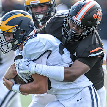 Clarkston running back Griffin Boman drags a Belleville tackler early in the 2024 Michigan high school football season.