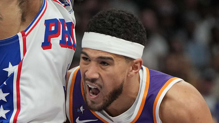 Feb 7, 2026; Phoenix, Arizona, USA; Phoenix Suns guard Devin Booker (1) drives on Philadelphia 76ers guard Kelly Oubre Jr. (9) during the first half of an NBA game at Mortgage Matchup Center. Mandatory Credit: Rick Scuteri-Imagn Images