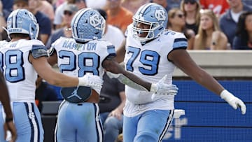Oct 26, 2024; Charlottesville, Virginia, USA; North Carolina Tar Heels running back Omarion Hampton (28) celebrates with Tar Heels offensive lineman Howard Sampson (79) after scoring a touchdown against the Virginia Cavaliers during the first half at Scott Stadium. Mandatory Credit: Geoff Burke-Imagn Images