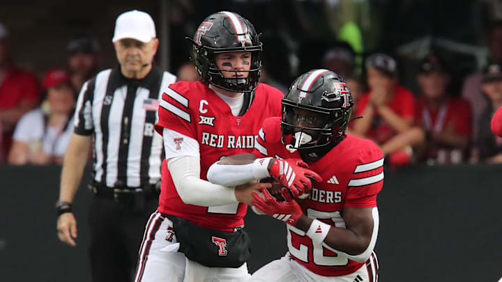 Sep 13, 2025; Lubbock, Texas, USA;  Texas Tech Red Raiders quarterback Behren Morton (2) hands the ball in the first half to running back J’Koby Williams (20) in the game against the Oregon State Beavers at Jones AT&T Stadium. Mandatory Credit: Michael C. Johnson-Imagn Images