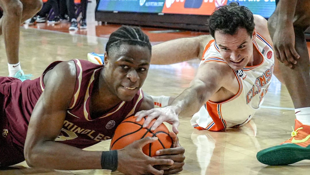 Clemson forward Nick Davidson (11) and Florida State University forward Thomas Bassong (3) dive for a loose ball during the second half at Littlejohn Coliseum in Clemson, S.C Saturday, February 21, 2026.