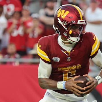 Sep 8, 2024; Tampa, Florida, USA;  Washington Commanders quarterback Jayden Daniels (5) runs the ball in for a touchdown against the Tampa Bay Buccaneers during the second half at Raymond James Stadium. Mandatory Credit: Kim Klement Neitzel-Imagn Images