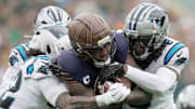 Green Bay Packers running back Josh Jacobs (8) runs for 18 yards before being tackled by Carolina Panthers safety Lathan Ransom (22) and cornerback Jaycee Horn (8) during the first quarter of their game Sunday, November 2, 2025 at Lambeau Field in Green Bay, Wisconsin.
