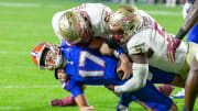 Florida Gators quarterback Max Brown (17) gets stopped by Florida State Seminoles defensive lineman Jared Verse (5) and Florida State Seminoles defensive lineman Braden Fiske (55) during first half action as Florida takes on Florida State at Steve Spurrier Field at Ben Hill Griffin Stadium in Gainesville, FL on Saturday, November 25, 2023. [Alan Youngblood/Gainesville Sun]